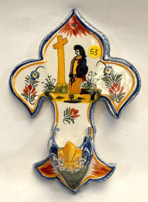 une croix en céramique ornée d'un oiseau, sur fond blanc