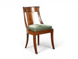 une image représentant une chaise en bois dont l'assise est recouverte d'un tissu vert