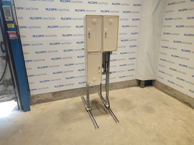 une boîte métallique posée sur un support devant un mur