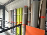 many rolls of paper on a rack in a warehouse