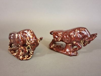 pair of ceramic figurines of a bull and a bear on a table