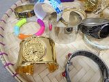 many different types of bracelets and rings on a table