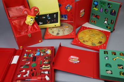 beaucoup de jouets dans une boîte rouge posée sur une table