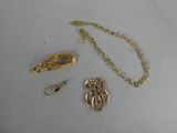 un collier en or et deux autres objets posés sur une table