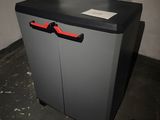 a grey cabinet with a red handle in a room