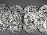 photographie en noir et blanc représentant un lot d'assiettes ornées de motifs