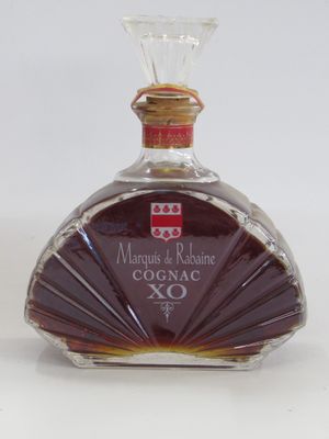 une bouteille de cognac posée sur une surface blanche