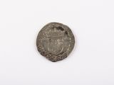 une vieille pièce d'argent sur laquelle figure une couronne, posée sur un fond blanc