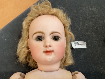 un gros plan d'une poupée posée sur une surface noire