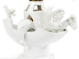 a white vase with a gold top and a white base
