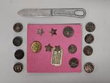 a knife and some coins on a pink piece of cloth