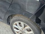 a black car that has been damaged and is parked on the side of the road