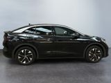 the black car is parked in a room with a white wall