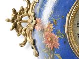 a blue vase with a clock on top of it
