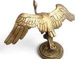 brass statue of a bird on a pedestal on a white background