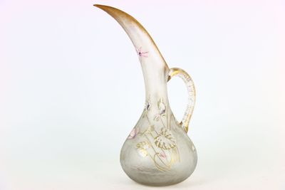 un vase en verre muni d'une anse incurvée, sur fond blanc