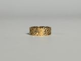 gros plan d'une bague en or sur une surface blanche