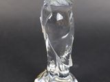 a clear glass owl figurine sitting on a black surface