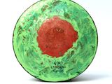 a green and red object with a red dot on it