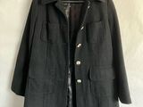 a black jacket hanging on a hanger on a white background