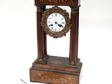 a small clock sitting on top of a table next to a piece of metal