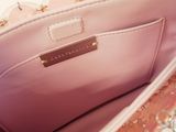someone is holding a pink purse with a chain around it