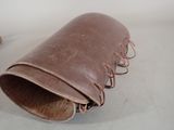 a brown leather bag with a wooden handle on a table