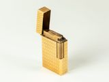a gold lighter that is sitting on a white surface