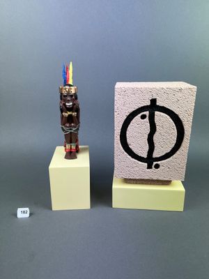 a small statue of a man standing next to a small statue of a man