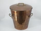 an old copper ice bucket with handles on a white background
