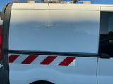 une camionnette blanche à rayures rouges garée sur un parking