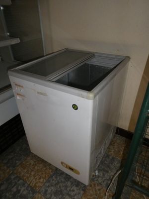 un réfrigérateur blanc posé dans le coin d'une pièce