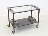 une table en métal et en verre équipée de deux roulettes