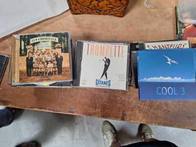 une table sur laquelle se trouvent plusieurs CD et un sac à main