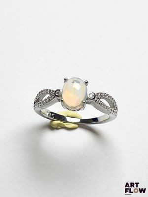 Une bague en oplite et diamant est présentée sur un fond blanc