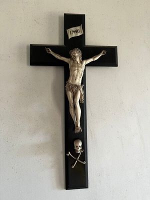 une statue de Jésus sur une croix accrochée au mur