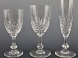 three wine glasses sitting on top of a table next to each other