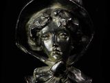 statue of a woman wearing a hat and a bow