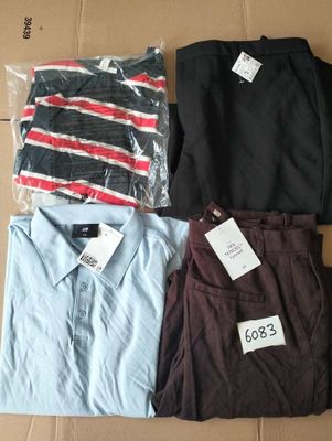 three men ' s shirts and a pair of pants on a cardboard box