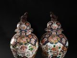 pair of chinese vases with flowers and birds on them against a black background