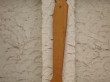 a wooden object on the floor next to a white wall
