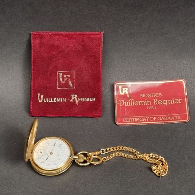 une montre de poche en or et un portefeuille rouge posés sur une table
