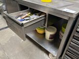 a metal workbench with a drawer full of tools