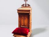 a small wooden chair with a red pillow on it