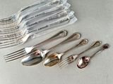 six spoons and six forks sitting next to each other on a table