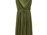 the green dress is hanging on a hanger on the wall