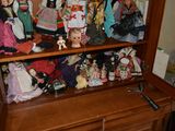 a wooden cabinet with many dolls on top of it