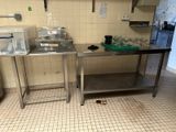 two stainless steel tables in a kitchen with a sink