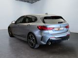 the rear end of a silver bmw car in a white room