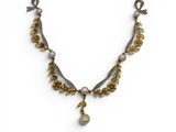 un collier composé de perles et de perles dorées sur fond blanc